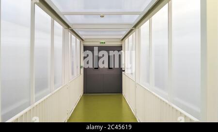 Couloir avec tapis vert et mur transparent dans un hôpital, France Banque D'Images