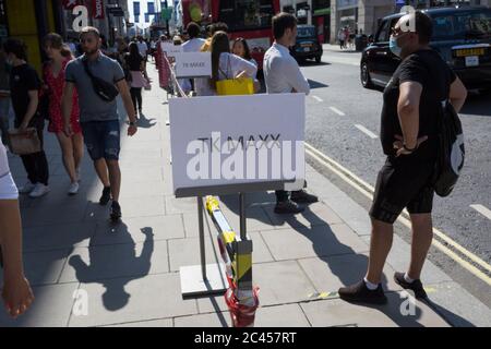 Les clients font la queue pour le magasin TK Max sur Oxford Street à Londres, le jour où le Premier Ministre britannique, Boris Johnson, a annoncé au Parlement un assouplissement majeur des restrictions de pandémie de coronavirus le 4 juillet prochain, y compris la réouverture de pubs, restaurants, hôtels et coiffeurs en Angleterre, le 23 juin 2020, À Londres, en Angleterre. La distance sociale de trois mois de deux mètres sera également réduite à un mètre plus mais au cours des 24 dernières heures, 171 autres sont morts de Covid, ce qui porte le total britannique à 42,927. Banque D'Images