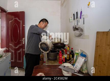 (200624) -- AKTO, 24 juin 2020 (Xinhua) -- Feng Guojie, chercheur en astronomie, cuisine dans sa région de vie du village de Subasi, dans le comté d'Akto, dans la région autonome de Xinjiang Uygur, dans le nord-ouest de la Chine, le 16 juin 2020. Situé dans la partie occidentale du Xinjiang, l'observatoire Muztagata, affilié à l'Observatoire astronomique de Xinjiang de l'Académie chinoise des sciences, se trouve à une altitude de 4,526 mètres. Il bénéficie d'une situation géographique unique et de superbes conditions d'observation pour l'observation astronomique. Étant donné les conditions de vie défavorables, le personnel ici travaille par quarts et vit dans le village de Subasi à un niveau relativement bas Banque D'Images