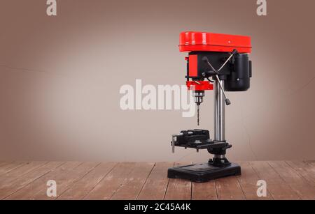 L'outil de travail des métaux - Nouvelle perceuse à percussion rouge sur une table en bois et un fond marron. Banque D'Images