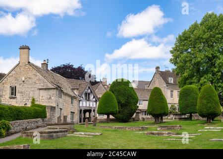 Église Saint-Marys, lychgate et arbres à if au soleil. Painswick, Cotswolds, Gloucestershire, Angleterre Banque D'Images