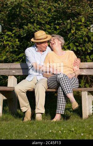 Happy senior couple sitting on a bench Banque D'Images
