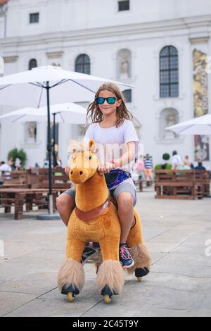 Jeune fille à cheval sur le vieux jeu à cheval à la foire du village Banque D'Images