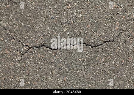 Surface asphaltée avec une fissure au milieu, arrière-plan. Texture détaillée du bitume en gros plan. Court-circuit à l'écran. Fondation routière Banque D'Images