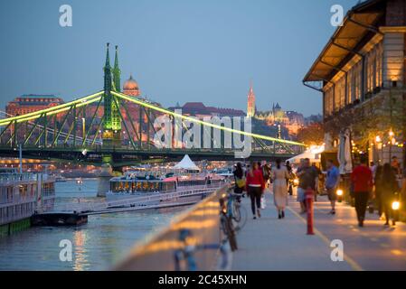 Promenade en bord de mer à Budapest la nuit, pont de la liberté, personnes à pied Banque D'Images