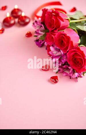 Bouquet de fleurs mixtes avec des roses, des bougies en forme de cœur et des décorations en acrylique Banque D'Images