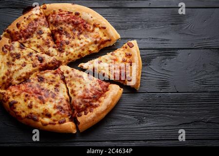 Pizza au pepperoni moelleux dans le style américain mis sur table en bois noir ancien rouillé Banque D'Images