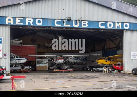 Vue sur la porte ouverte du Como Aero Club et hangar plein de différents types d'hydravions. Banque D'Images