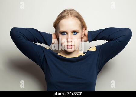 Jolie fille mode avec maquillage porter une manches longues bleue sur fond blanc Banque D'Images