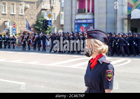 Donetsk, Donetsk People Republic - 24 juin 2020 : jolie policewoman en premier plan dans le masque du coronavirus. La police marche le long de la rue principale de la Banque D'Images