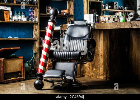 Coiffeur dans l'intérieur de la barbershop. Chaise de salon de coiffure. Fauteuil de barbershop, salon, salon de coiffure pour hommes. Poteau de salon de coiffure. Logo du barbershop Banque D'Images