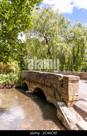 La rivière Coln qui coule sous le pont dans le village de Cotswold à Ablington, Gloucestershire, Royaume-Uni Banque D'Images