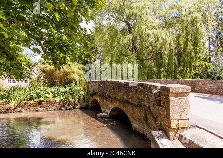 La rivière Coln qui coule sous le pont dans le village de Cotswold à Ablington, Gloucestershire, Royaume-Uni Banque D'Images