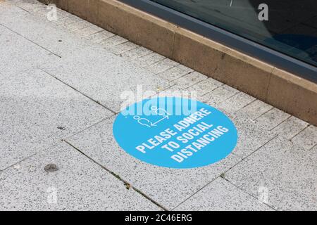 Une photographie des mesures de distanciation sociale à l'extérieur d'un magasin Cardiff Primark avec volets. Pas encore ouvert au public, comme d'autres magasins non essentiels l'ont été Banque D'Images