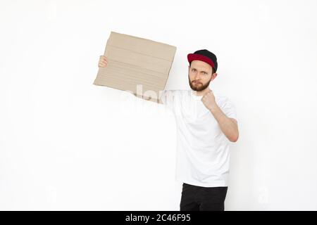 Jeune homme protestant avec un tableau blanc, panneau isolé sur fond blanc de studio. Activisme, position sociale active, protestation, problèmes réels. Réunion contre les droits de l'homme, l'abus, la liberté de choix. Banque D'Images