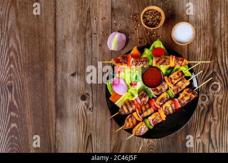 Poulet grillé sur une brochette de bois avec sauce chaude. Banque D'Images