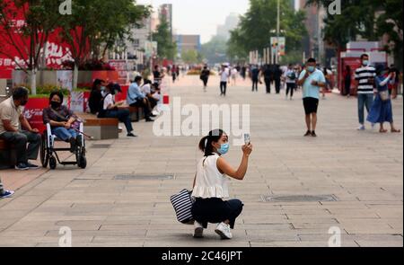 Pékin, Chine. 24 juin 2020. Une femme chinoise prend des photos d'une zone commerciale touristique presque vide, la menace du « coved-19 » restant au niveau 2 à Pékin le mercredi 24 juin 2020. De nombreuses zones commerciales et touristiques ont été recostées alors que les cas de coronavirus ont augmenté dans la capitale la semaine dernière. Photo de Stephen Shaver/UPI crédit: UPI/Alay Live News Banque D'Images