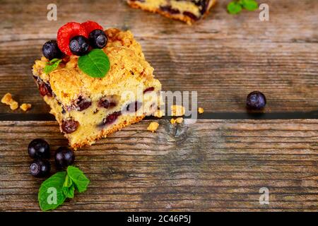 Morceau de tarte aux myrtilles avec baies fraîches sur fond de bois. Banque D'Images