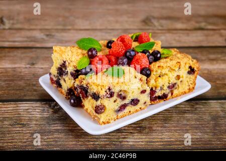 Gâteau à la crème sure avec bleuets frais sur une assiette blanche. Banque D'Images