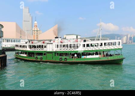 Hong Kong, Chine - 30 avril 2017 : les touristes apprécient la navigation sur le bateau à vapeur traditionnel Star Ferry dans le port de Victoria avec la célèbre ligne d'horizon à l'arrière en H Banque D'Images
