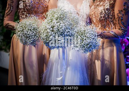 Filles tenant des bouquets blancs de fleurs dans les mains Banque D'Images