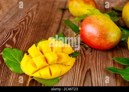Délicieuse mangue sucrée coupée sur fond de bois. Banque D'Images