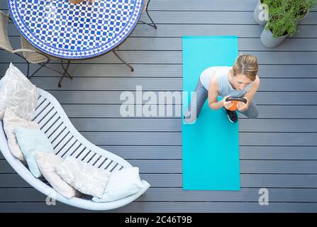 Vue de dessus de la femme mature en bonne santé à la maison exercice sur le pont avec la bouilloire Bell poids Banque D'Images