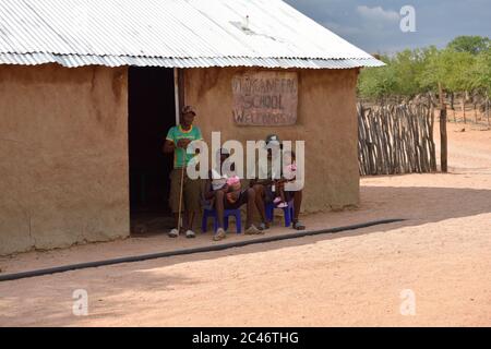 KAMANJAB, NAMIBIE - 1 FÉVRIER 2016 : des hommes Himba non identifiés avec des enfants sont montrés dans le village de la tribu himba près de l'école Banque D'Images