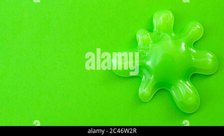 Pratique Joke Splash, jouet drôle et splatter concept avec un blob vert néon de mucus ou goo isolé sur fond vert blanc avec un texte spac Banque D'Images