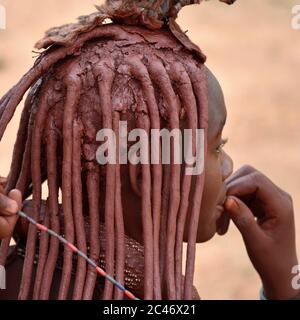 KAMANJAB, NAMIBIE - 1 FÉVRIER 2016: Jeune femme Himba non identifiée avec la coiffure typique montré en plein air Banque D'Images