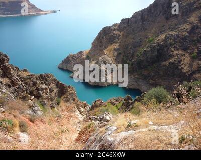 Beau lac Charvak en Ouzbékistan avec eau bleue claire. Vue sur le lac depuis la montagne. Banque D'Images