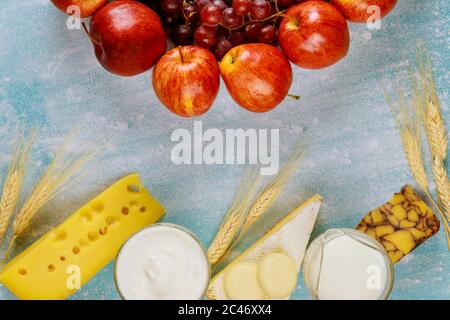 Fruits, fromage et lait sur fond bleu pour Shavuot. Banque D'Images