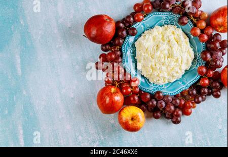 Fromage cottage avec raisins et pommes sur fond bleu. Concept Shavuot ou Thanksgiving Day. Banque D'Images