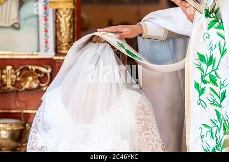 Prêtre couvrant la tête de mariée cassock dans l'église Banque D'Images