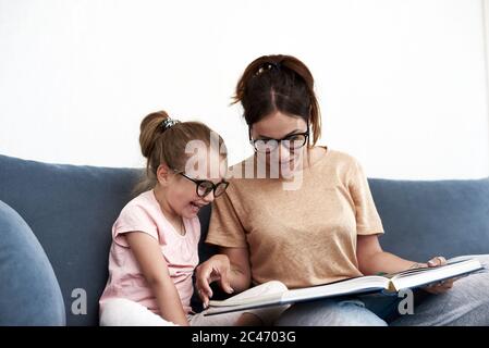 Mère et fille lisent un livre. Mère enseigne une petite fille. Banque D'Images