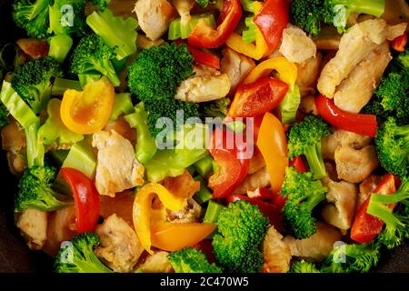 Saupousser les légumes avec le poulet dans une casserole sur une surface en bois blanc. Gros plan. Banque D'Images
