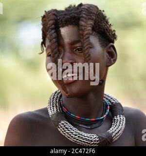 KAMANJAB, NAMIBIE - 1 FÉVRIER 2016: Jeune fille Himba non identifiée avec le collier typique et la double coiffure de la tresse de pré-adolescent Banque D'Images