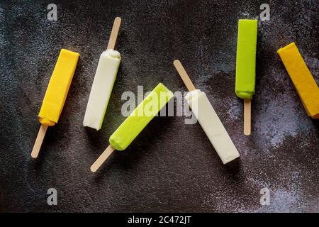 Glace glacée glace glacée aux fruits popsicle sur fond sombre. Vue de dessus. Banque D'Images
