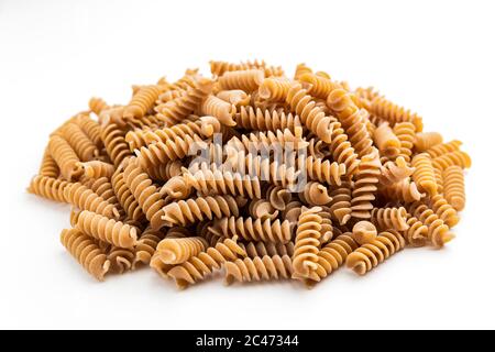 Pile de pâtes fusilli à grains entiers sur fond blanc Banque D'Images