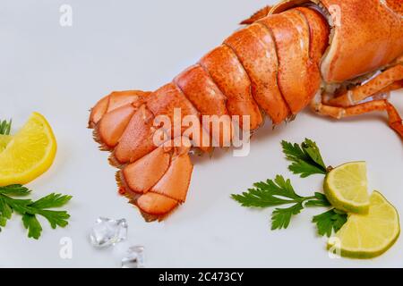 Délicieux plat de queue de crabe avec citron et persil sur fond blanc. Banque D'Images