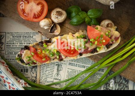 Pain italien, baguette au salami et fromage jaune enveloppés dans du papier Banque D'Images