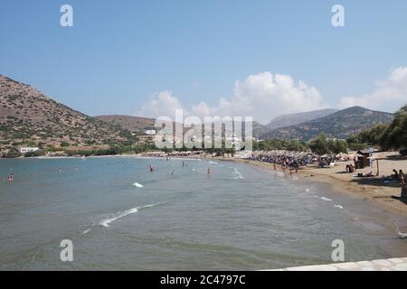 La plage de la station touristique de Galissas sur la belle île grecque de Syros. Les baigneurs profitent du soleil d'été au magnifique coucher du soleil. Banque D'Images
