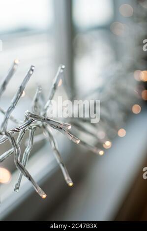 Lampes DE noël À DEL qui s'allument sur la fenêtre Banque D'Images