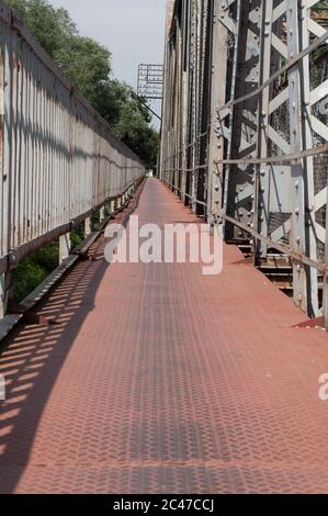 Passerelle piétonne rouge sur le pont en fer Banque D'Images