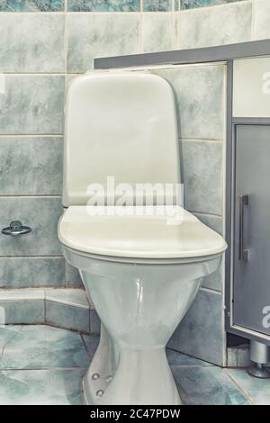 Cuvette de toilette montée en blanc dans la salle de bains moderne avec miroir et brosse de toilette Banque D'Images