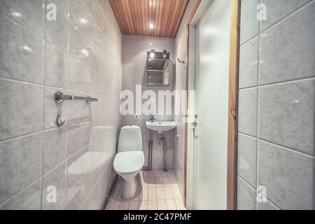 Cuvette de toilette montée en blanc dans la salle de bains moderne avec miroir et brosse de toilette Banque D'Images