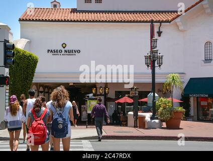 Vue arrière des clients traversant la rue pour entrer dans le centre commercial Paseo Nuevo avec des boutiques et des restaurants dans le centre-ville de Santa Barbara, CA, États-Unis Banque D'Images