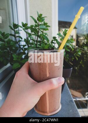 Smoothie rose maison frais avec bleuets séchés, feuilles de noix de coco et de menthe sur le dessus. Alimentation saine avec fruits. Banque D'Images