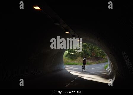 Un cycliste est à vélo depuis un tunnel sur le sentier Galloping Goose Trail, dans la ville de View Royal, dans le grand Victoria. L'ancien chemin de fer est utilisé par les piétons Banque D'Images