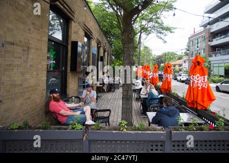 Toronto, Canada. 24 juin 2020. Les gens dînent sur la terrasse d'un restaurant à Toronto, Canada, le 24 juin 2020. La ville de Toronto a passé à la prochaine étape de la réouverture économique mercredi dans le contexte de la pandémie COVID-19, avec levée des restrictions pour les terrasses de restaurants, les salons de coiffure et les centres commerciaux. Credit: Zou Zheng/Xinhua/Alamy Live News Banque D'Images